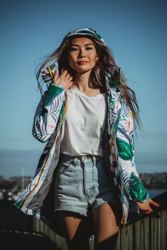 Scribbler rainwear, waterproof raincoat for women, rain jacket for ladies, outerwear, waterproof, mesh lined, lightweight, recycled plastic, sustainable fashion, winter coat, tropical Tropic print, mesh lined, beautiful, colourful print, breathable, packable coat, NZ, New Zealand designer, plus size, curvy, curves, white, green leaves, strelitzia, colourful rain jacket