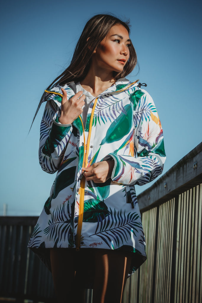 Scribbler rainwear, waterproof raincoat for women, rain jacket for ladies, outerwear, waterproof, mesh lined, lightweight, recycled plastic, sustainable fashion, winter coat, tropical Tropic print, mesh lined, beautiful, colourful print, breathable, packable coat, NZ, New Zealand designer, plus size, curvy, curves, white, green leaves, strelitzia, colourful rain jacket