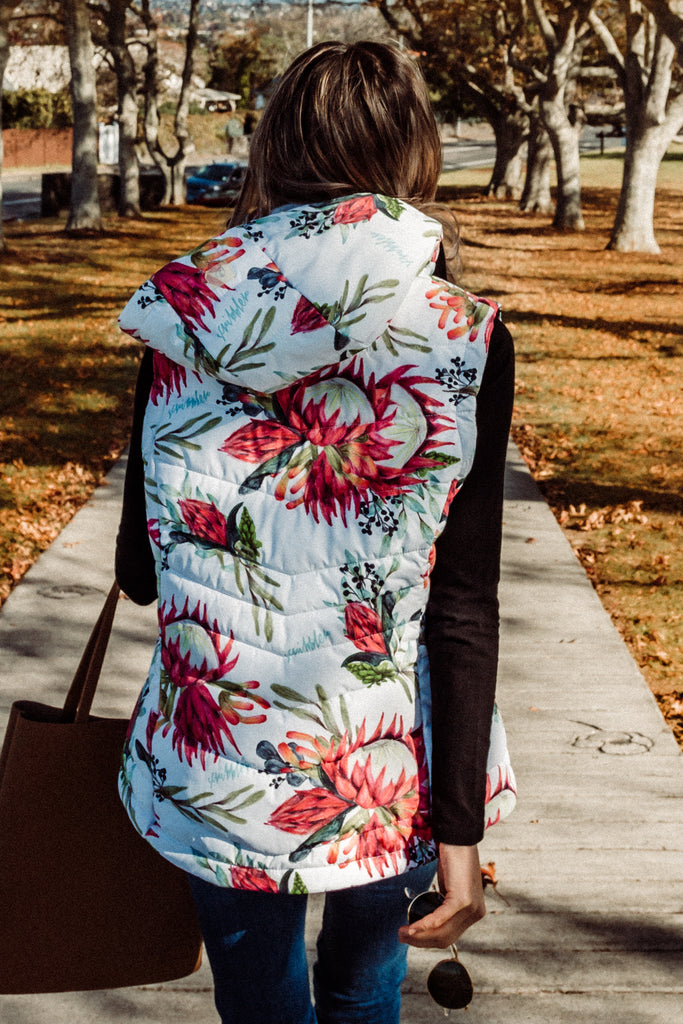 Scribbler protea vest, African protea print, White puffer vest, waterproof gilet, recycled fabric, recycled puffer, conscious fashion, plus size vest, floral vest, removable hood, botanical print, quilted vest, plus size vest, NZ, New Zealand, Australia, USA