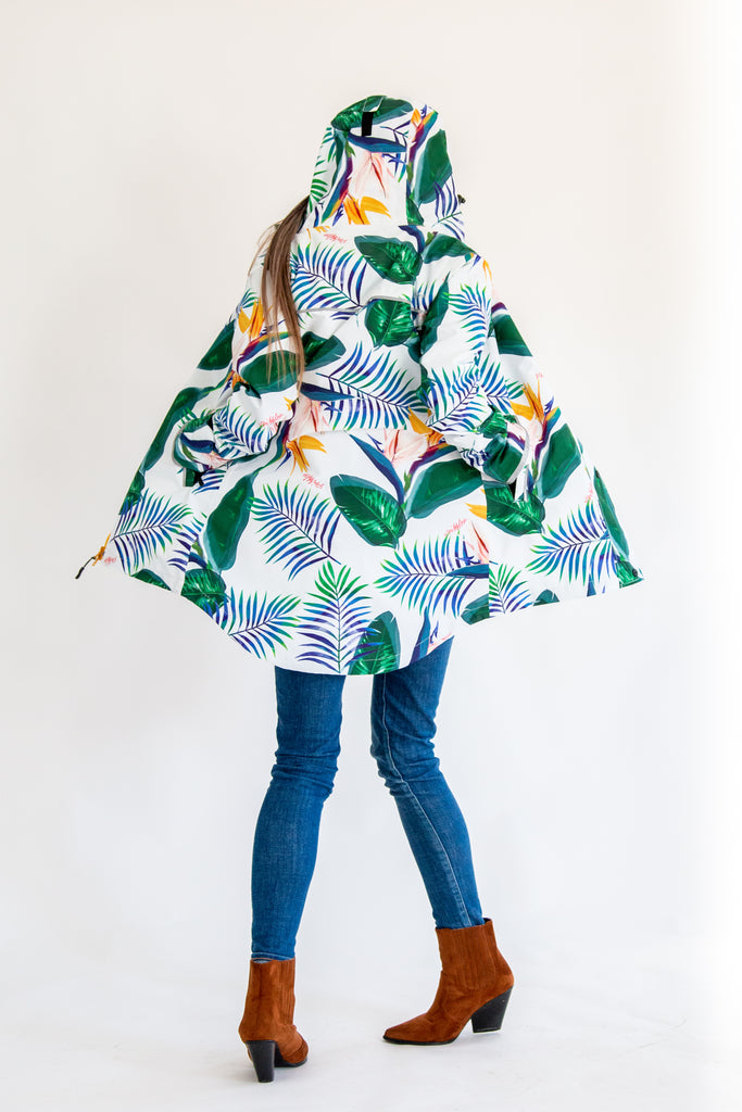 Scribbler rainwear, waterproof raincoat for women, rain jacket for ladies, outerwear, waterproof, mesh lined, lightweight, recycled plastic, sustainable fashion, winter coat, tropical Tropic print, mesh lined, beautiful, colourful print, breathable, packable coat, NZ, New Zealand designer, plus size, curvy, curves, white, green leaves, strelitzia, colourful rain jacket